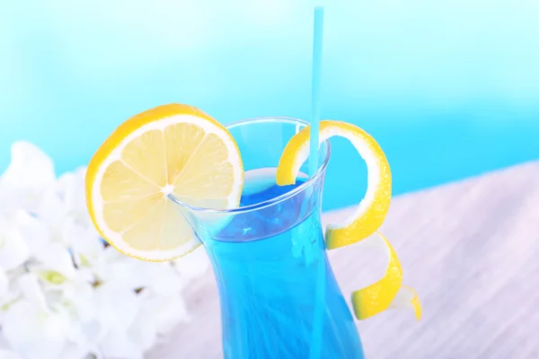 Vaso de cóctel sobre mesa sobre fondo azul claro — Foto de Stock