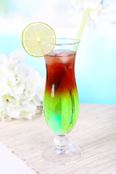 Vaso de cóctel sobre mesa sobre fondo azul claro — Foto de Stock