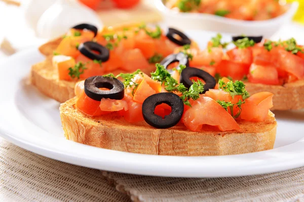 おいしいテーブルのクローズ アップのプレートにトマトのブルスケッタ — ストック写真