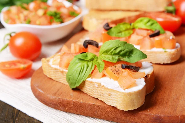 Herkullinen bruschetta tomaattien kanssa leikkuulaudalla lähikuva — kuvapankkivalokuva