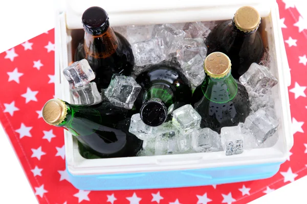 Pecho de hielo lleno de bebidas en botellas en servilleta de color, aislado en blanco — Foto de Stock