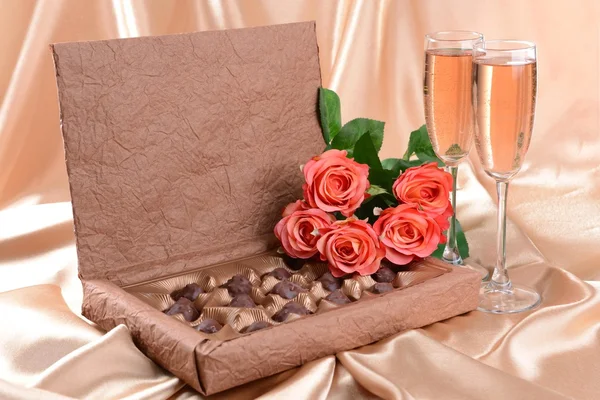 Смачні шоколадки в коробці з квітами на золотому фоні — стокове фото