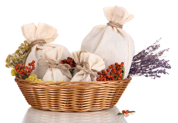 Textile sachet pouches with dried flowers, herbs  and berries  in wicker basket, isolated on white — Stock Photo, Image