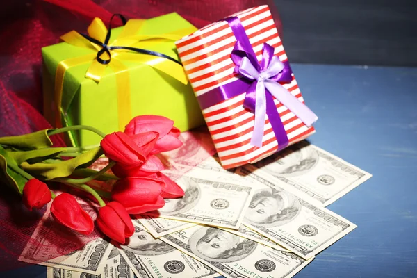 Geschenkdoos met geld en bloemen op houten tafel, op donkere achtergrond — Stockfoto