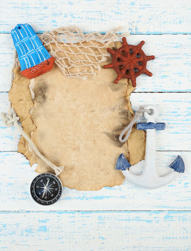 Old paper with sea accessories, isolated on wooden background