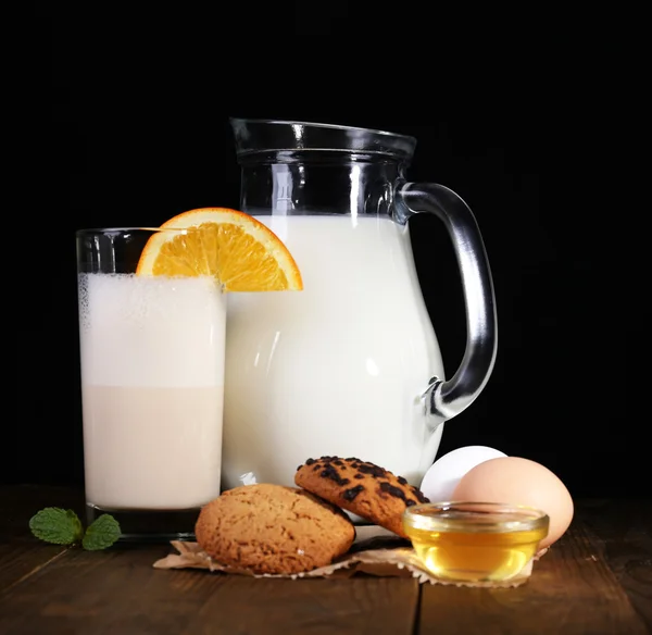 Vaječný likér s mlékem a vejci na stůl a černým pozadím — Stock fotografie