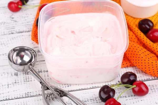 Sorvete em recipiente e colher de sorvete em mesa de madeira close-up — Fotografia de Stock