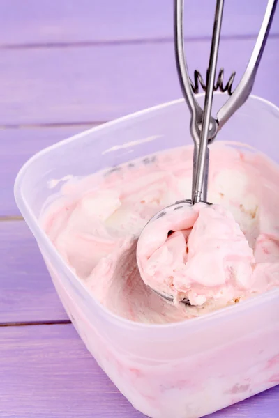Ice cream in container and ice cream spoon on wooden table close-up — Stock Photo, Image