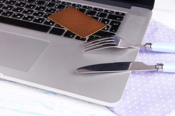 Cartão de crédito com garfo e faca no teclado do computador na mesa de perto — Fotografia de Stock