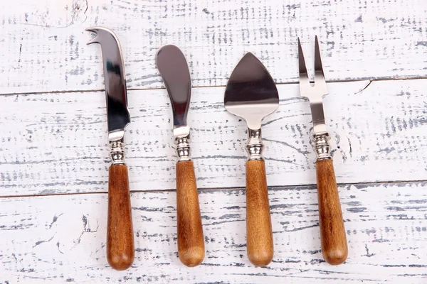 Set of cheese knives on wooden table close-up — Stock Photo, Image