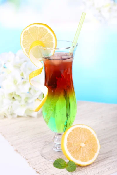 Vaso de cóctel sobre mesa sobre fondo azul claro — Foto de Stock