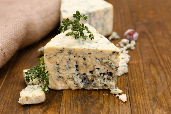Smakelijke blauwe kaas met tijm, op houten tafel — Stockfoto