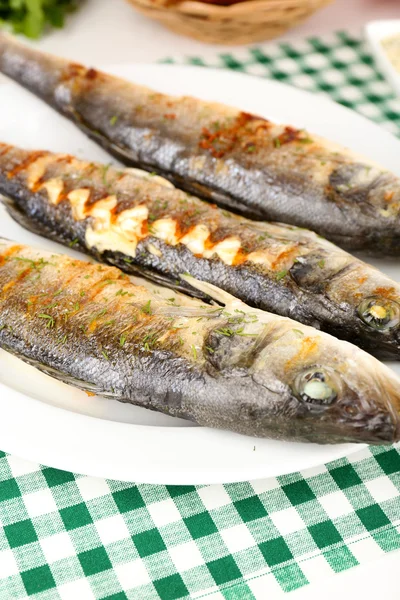 Delicious grilled fish on plate on table close-up — Stock Photo, Image