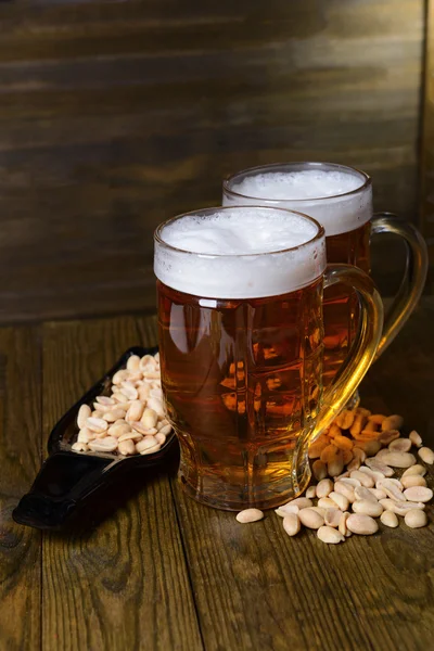 Bicchieri di birra con spuntino sul tavolo su sfondo di legno — Foto Stock