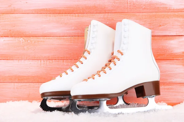 Figure skates on orange wooden background — Stock Photo, Image