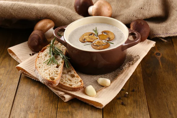 Mushroom soup in pot, on wooden background — Stock Photo, Image