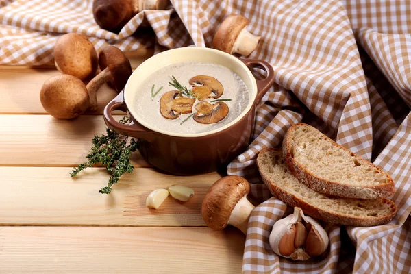 Sopa de champiñones en olla, en servilleta, sobre fondo de madera — Foto de Stock