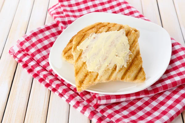 Grilled bread with butter on wooden table — Stock Photo, Image