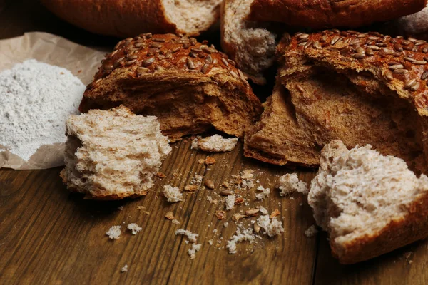 Breaking bread on wooden table — Stock Photo, Image