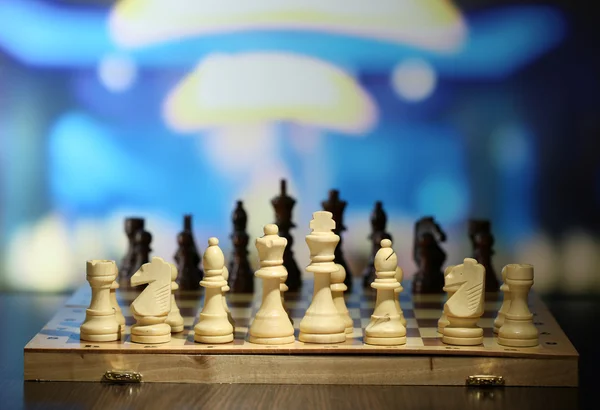 Šachové figurky na palubě na světlé pozadí — Stock fotografie
