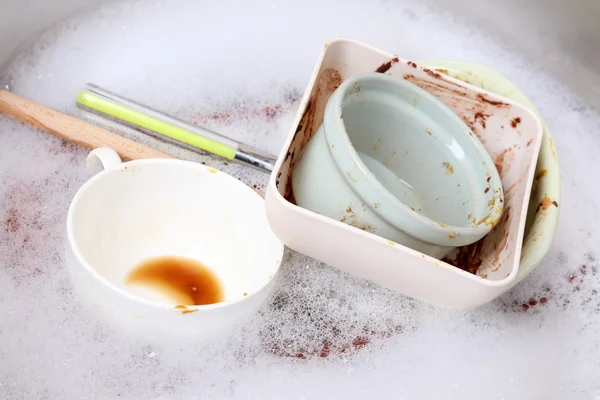 Utensils soaking in kitchen sink — Stock Photo, Image