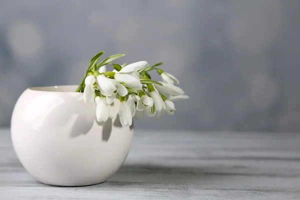 Bellissimo bouquet di bucaneve in vaso su sfondo chiaro — Foto Stock