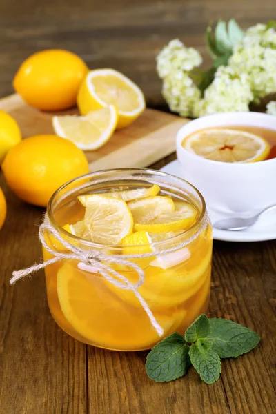 Tasty lemon jam with cup of tea on table close-up — Stock Photo, Image