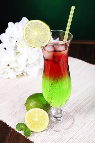 Bicchiere di cocktail sul tavolo su sfondo verde scuro — Foto Stock