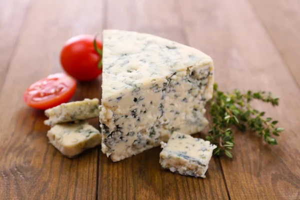 Gustoso formaggio blu con timo e pomodoro, sul tavolo di legno — Foto Stock