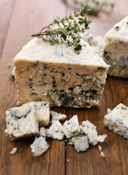 Savoureux fromage bleu au thym, sur table en bois — Photo