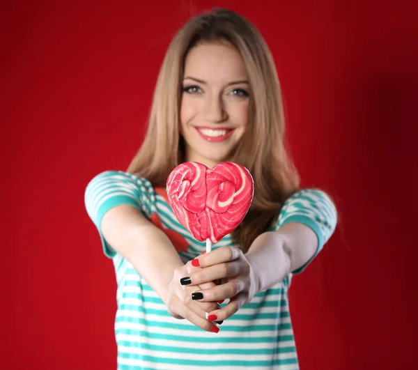 Ragazza felice con lecca-lecca su sfondo a colori — Foto Stock