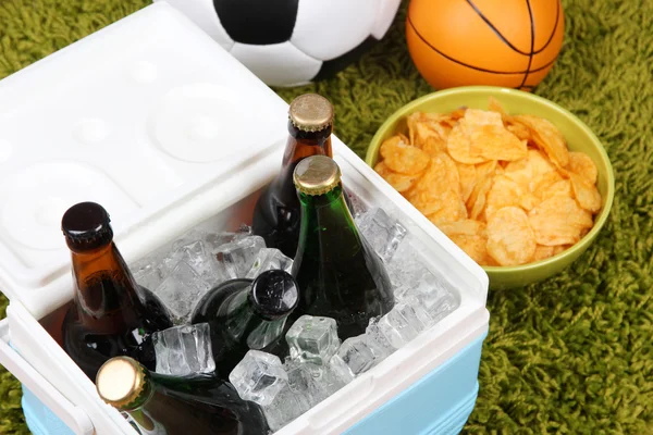 Ice chest full of drinks in bottles on color carpet background — Stock Photo, Image