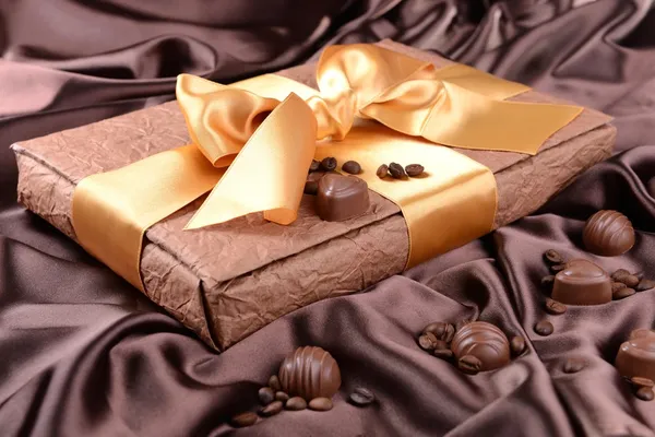 Läckra chokladpraliner i rutan på brun bakgrund — Stockfoto