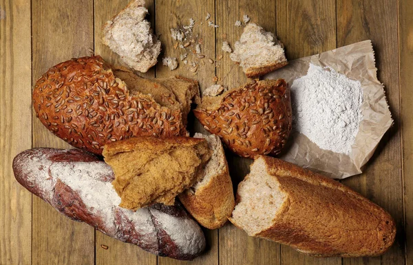 Partir o pão na mesa de madeira — Fotografia de Stock