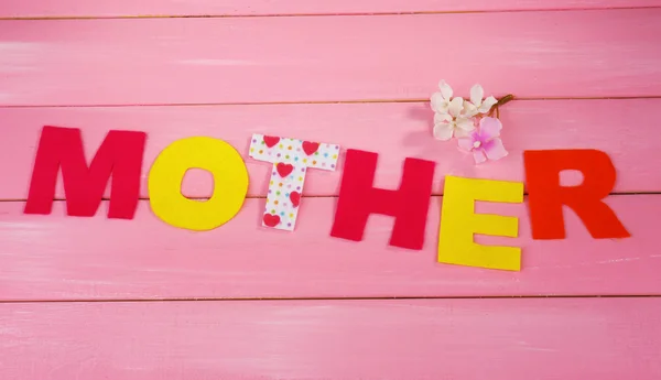 Madre - letras de letras de papel hechas a mano sobre fondo de madera rosa — Foto de Stock