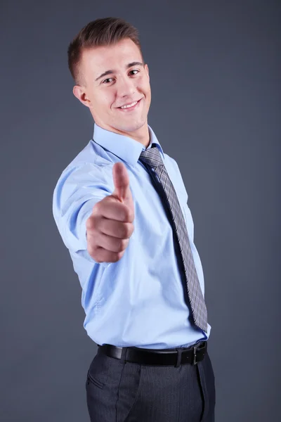 Joven guapo sobre fondo gris — Foto de Stock