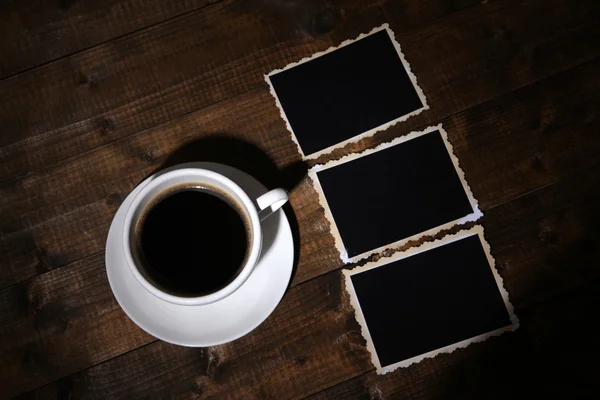 Taza de café y viejas fotos en blanco, sobre fondo de madera — Foto de Stock
