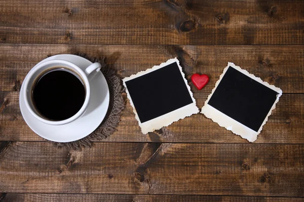 Composizione con tazza di caffè, cuori decorativi e vecchie foto in bianco, su sfondo di legno — Foto Stock