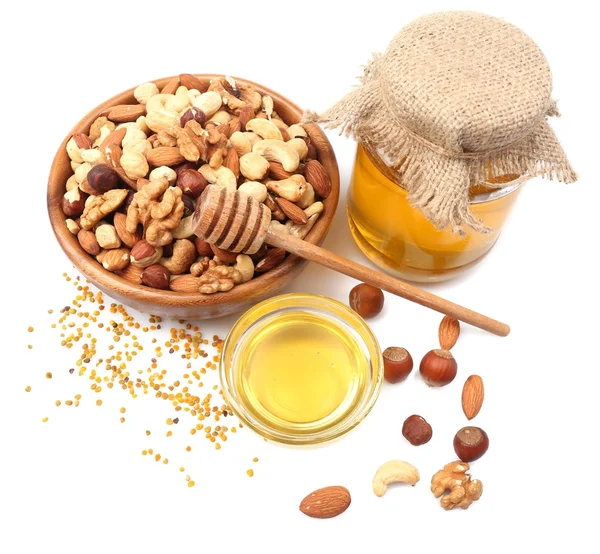 Zoete honing en verschillende noten, geïsoleerd op wit — Stockfoto