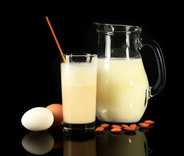 Vaječný likér s mlékem a vejci na černém pozadí — Stock fotografie