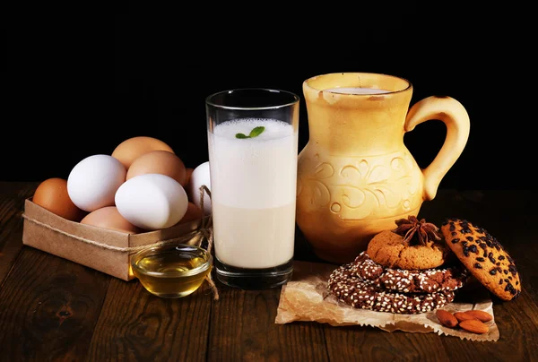 Eggnog with milk and eggs on table and black background — Stock Photo, Image