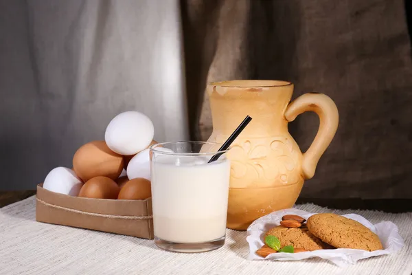 Eierlikör mit Milch und Eiern auf Tisch und Stoffhintergrund — Stockfoto