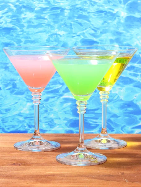 Bicchieri di cocktail su tavolo di legno su sfondo blu mare — Foto Stock