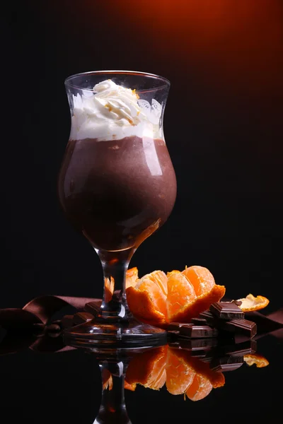 Sobremesa saborosa com chocolate, creme e molho de laranja, no fundo de cor escura — Fotografia de Stock