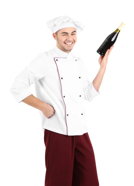 Chef profesional en uniforme blanco y sombrero, sosteniendo botella de vino, aislado en blanco — Foto de Stock