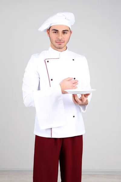 专业的厨师，在白色的制服和帽子，在灰色的背景上 — 图库照片