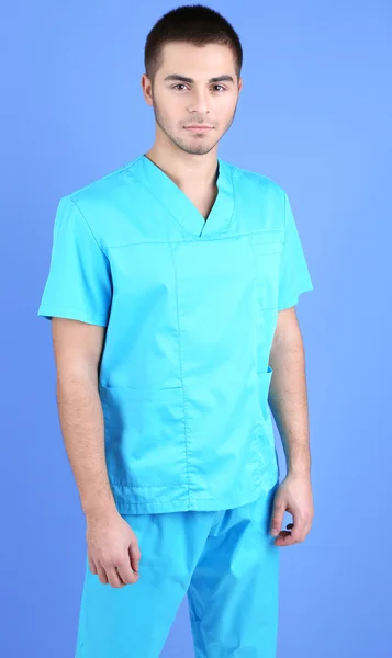 Jovem médico do sexo masculino em fundo azul — Fotografia de Stock
