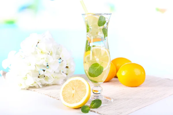 Glas cocktail met citroen en mint op tafel op lichte blauwe achtergrond — Stockfoto