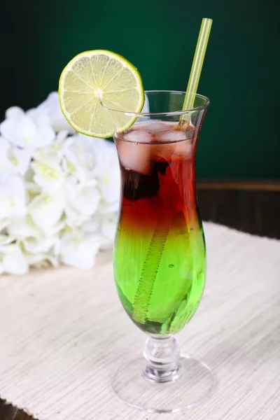 Bicchiere di cocktail sul tavolo su sfondo verde scuro — Foto Stock