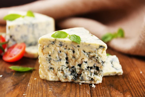 Sabroso queso azul con albahaca y tomate, sobre mesa de madera — Foto de Stock